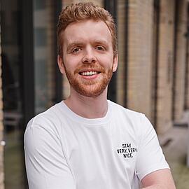 Ein Mitarbeiter der Stayery namens Kevin in einem weißen Stayery-T-Shirt
